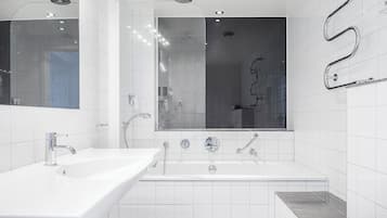 A modern bathroom with a white sink, a large mirror, and a bathtub.