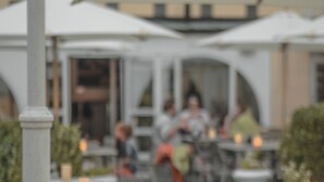 An outdoor seating area with tables and chairs, surrounded by greenery. - ProfilHotels Grand Kristianstad (Kristianstad)