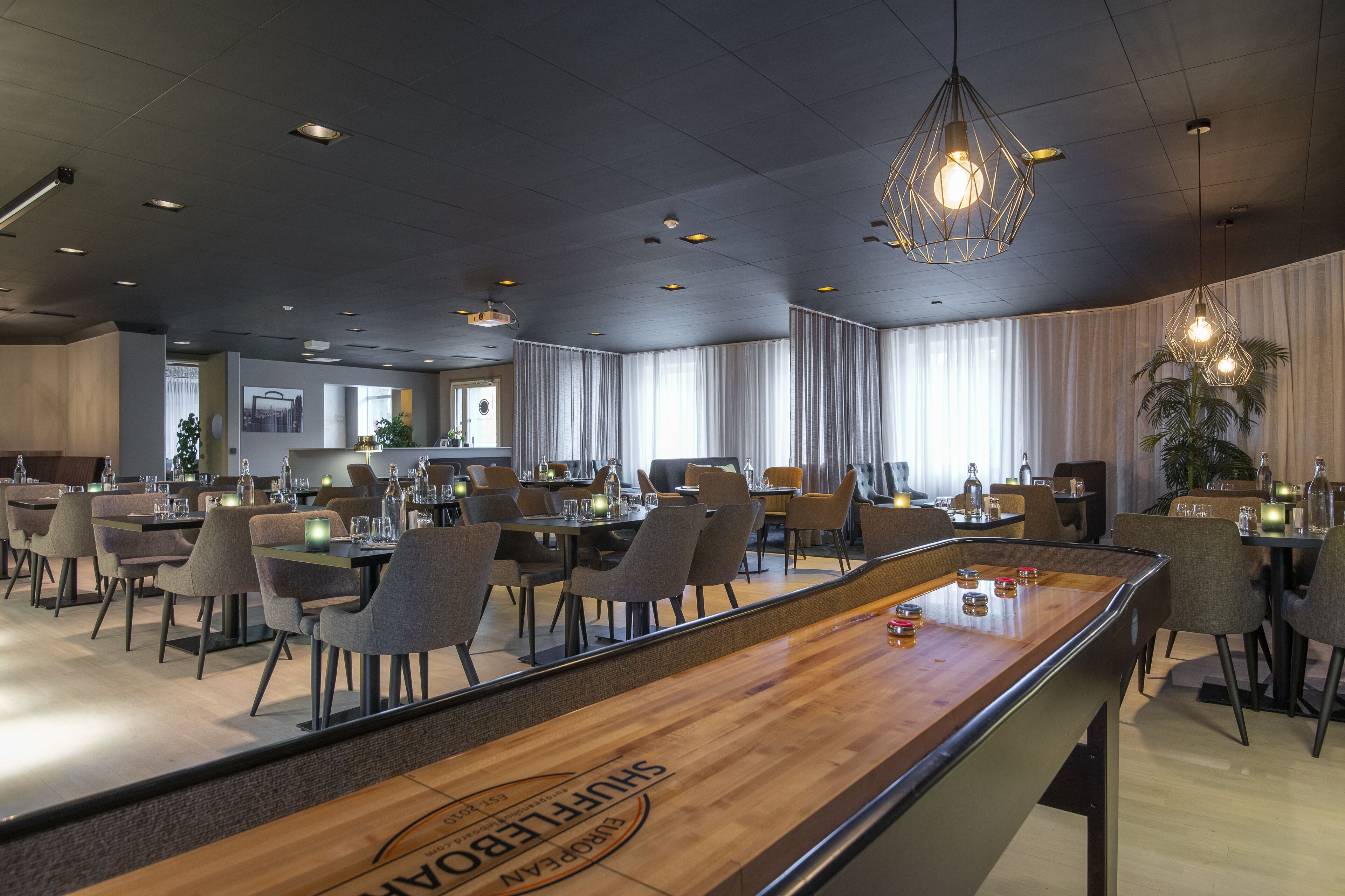 Un restaurante moderno con mesa de billar, mesas y sillas para comer.