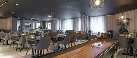 Un restaurante moderno con mesa de billar, mesas y sillas para comer.