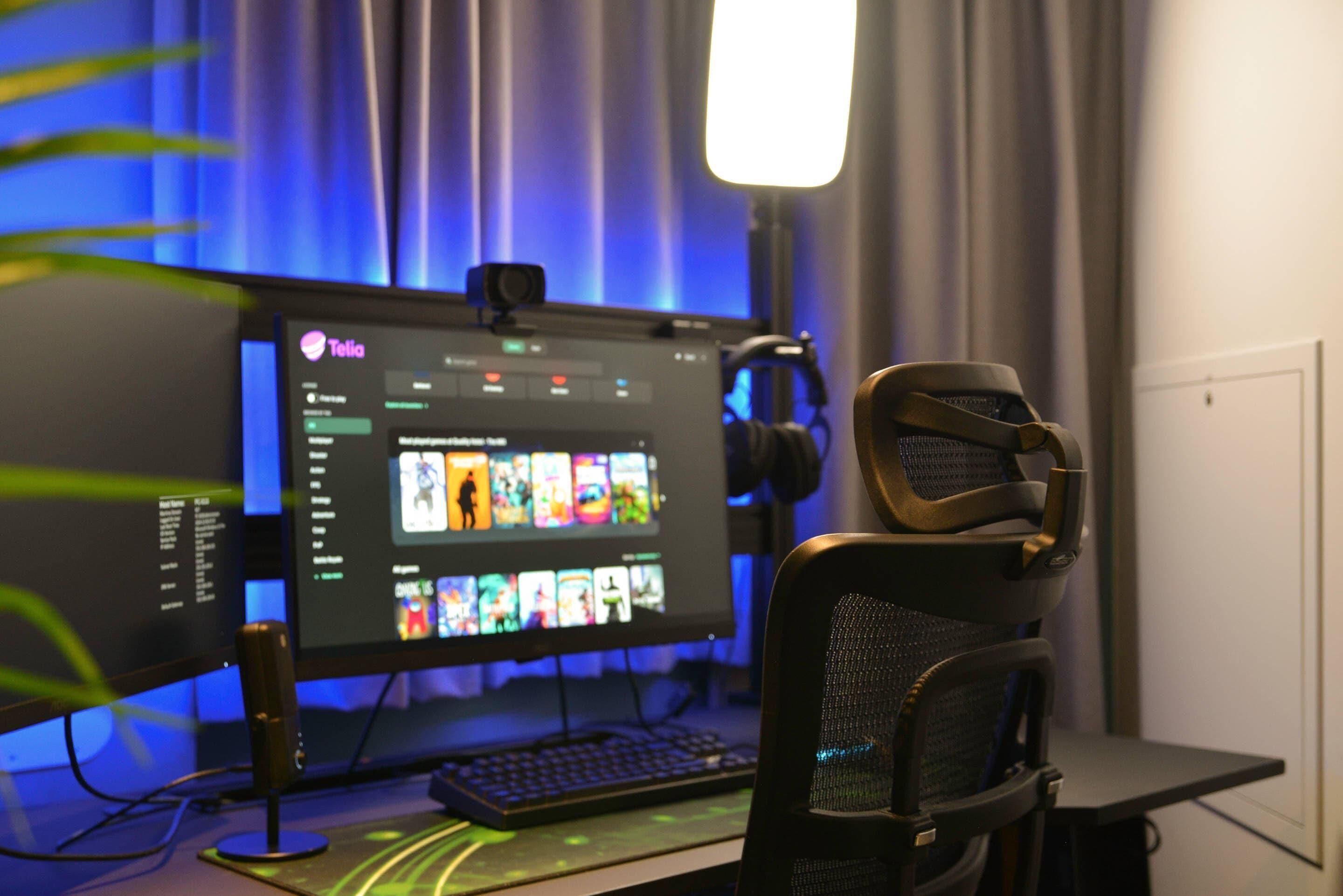 A computer setup with a monitor displaying a media player interface, a keyboard, and a gaming chair.