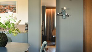A modern room with a large mirror, a dining table with chairs, a vase of flowers, and a painting on the wall. - Quality Hotel the Mill (Malmö)