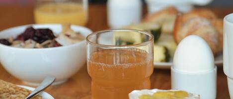 Una mesa de desayuno con diferentes platos, incluyendo tostadas, huevos y un vaso de jugo de naranja.