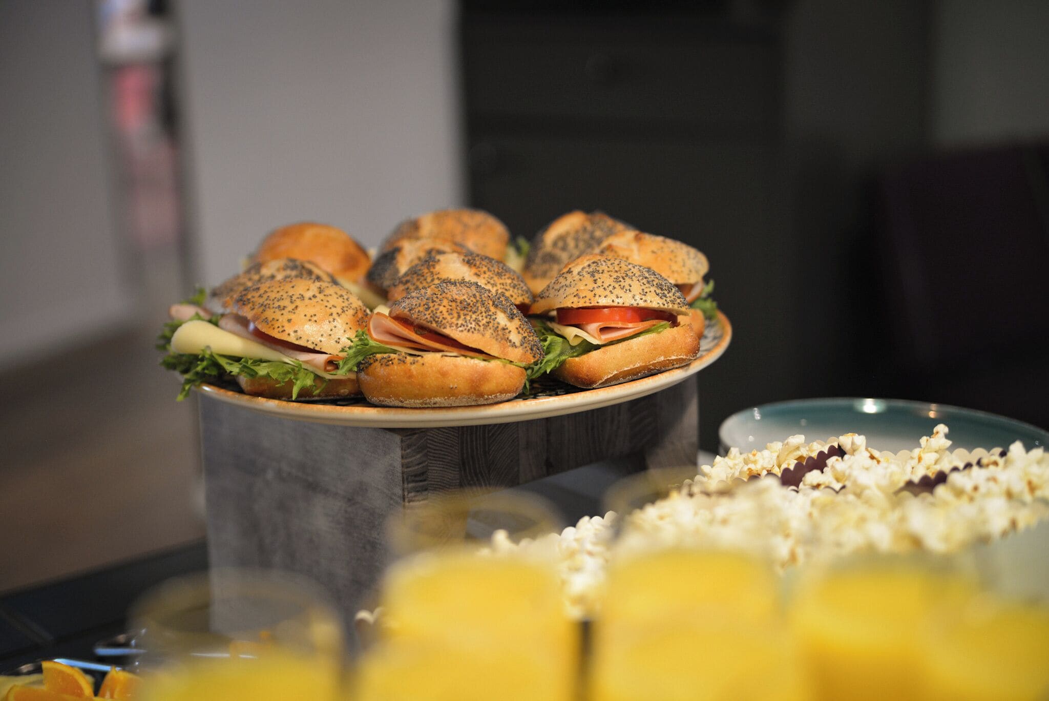 A tray of sandwiches with poppy seeds on a wooden stand.