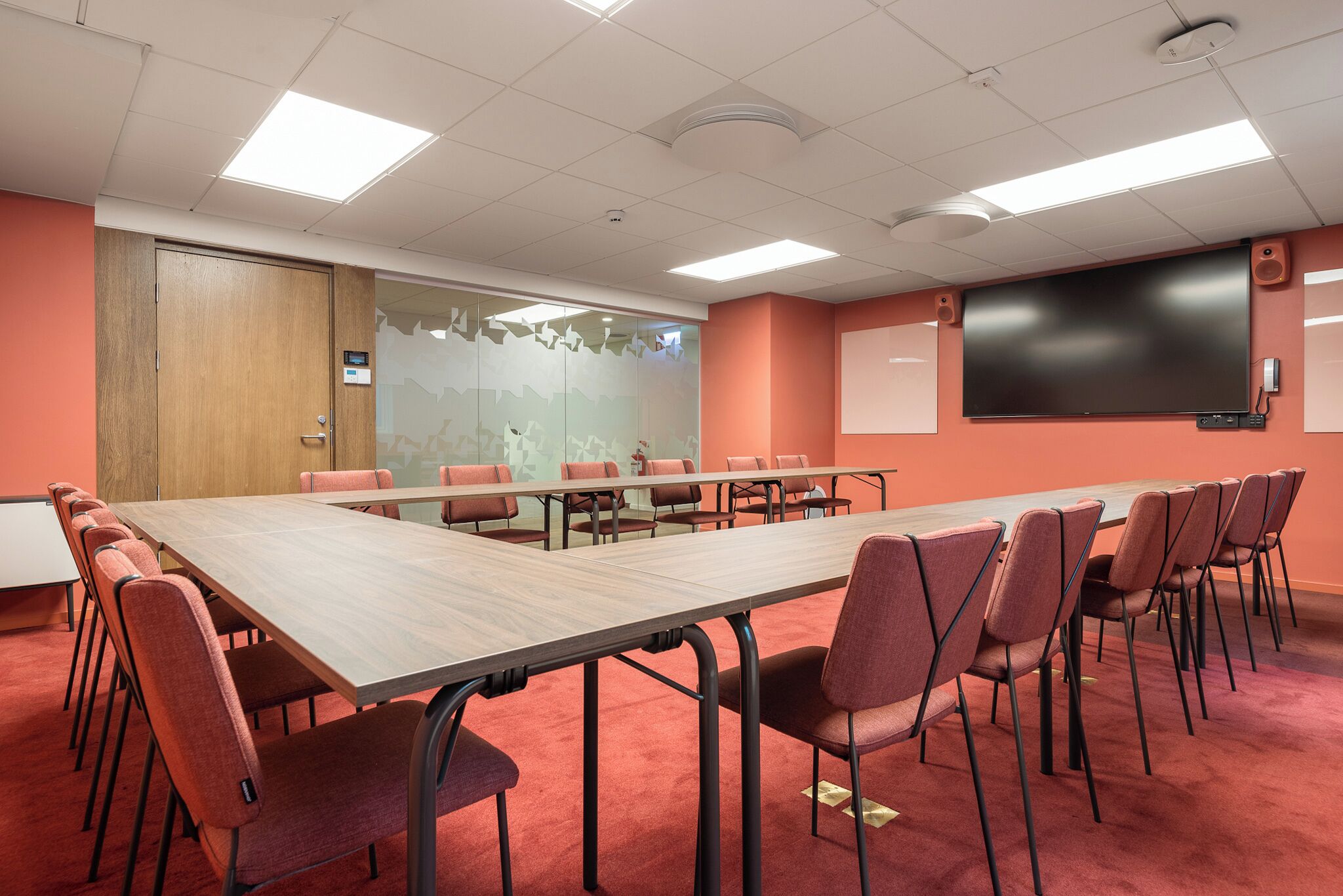 A conference room with a long table and chairs, a projector screen, and a whiteboard.