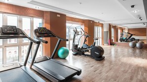 Ein Fitnessstudio mit Laufbändern, Crosstrainern und Trainingsbällen.