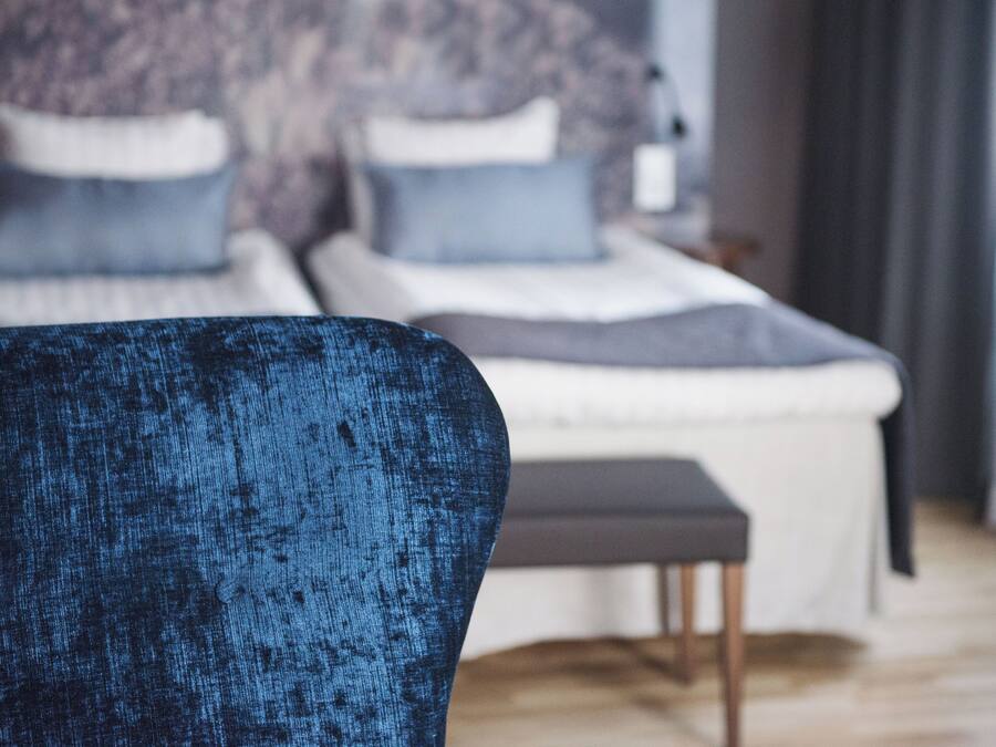 A bedroom with a bed, a chair, and a small table.