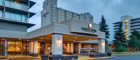 Un hotel de diseño moderno, con una entrada destacada, varios pisos y una fachada bien iluminada.