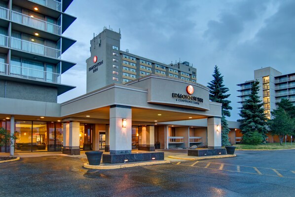A hotel with a modern design, featuring a prominent entrance, multiple floors, and a well-lit facade.