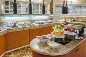 A buffet setup with various food items and condiments.