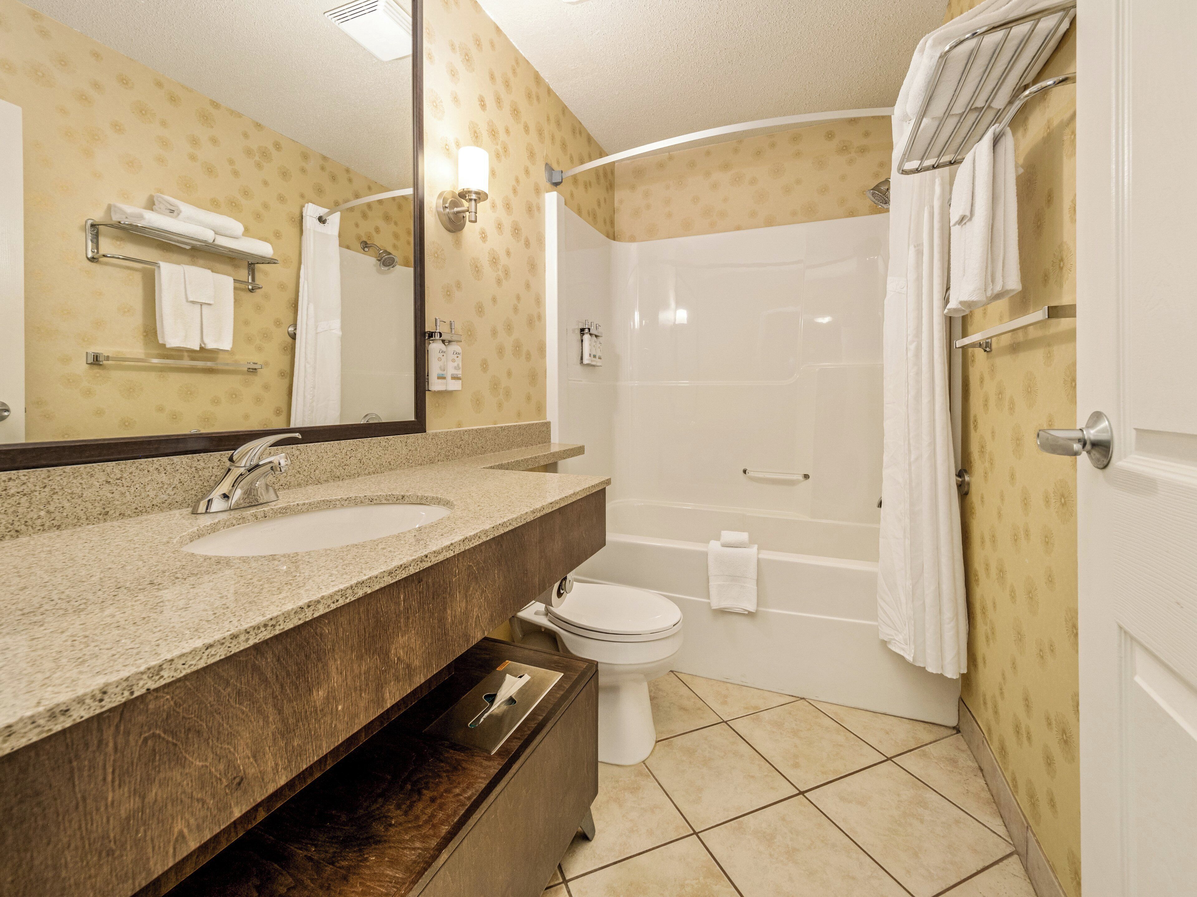 A bathroom with two sinks, a toilet, and a shower.