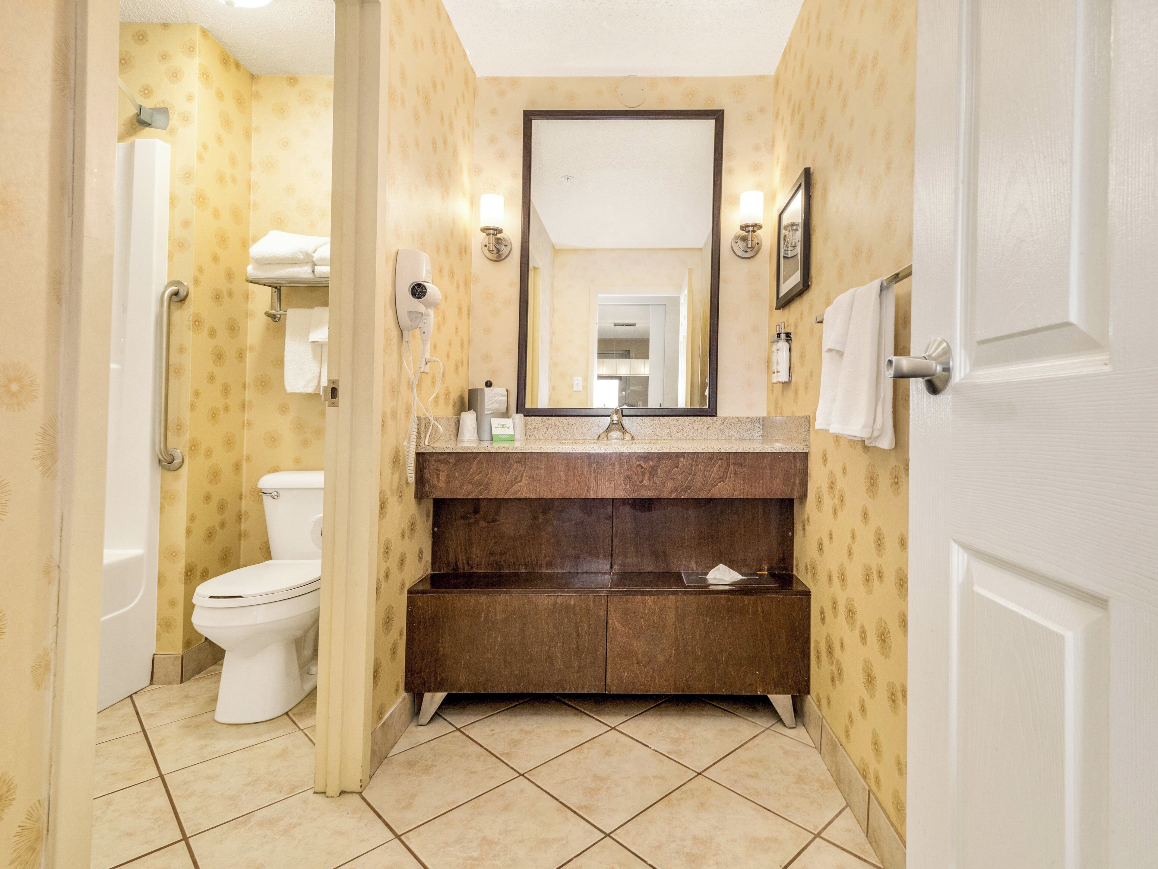 Une salle de bain avec des toilettes, un lavabo et une douche.