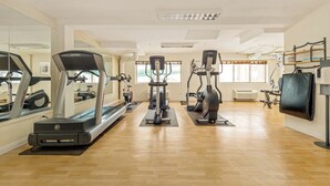 A spacious gym with cardio machines, mirrors, and a wooden floor. - Holiday Inn Lethbridge by IHG (Lethbridge)