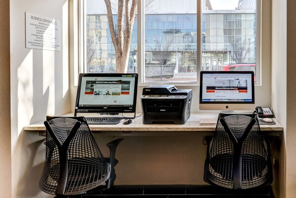 A workspace with two computers, a printer, and two mesh chairs. - Holiday Inn Express Washington DC N-Silver Spring by IHG (Silver Spring)