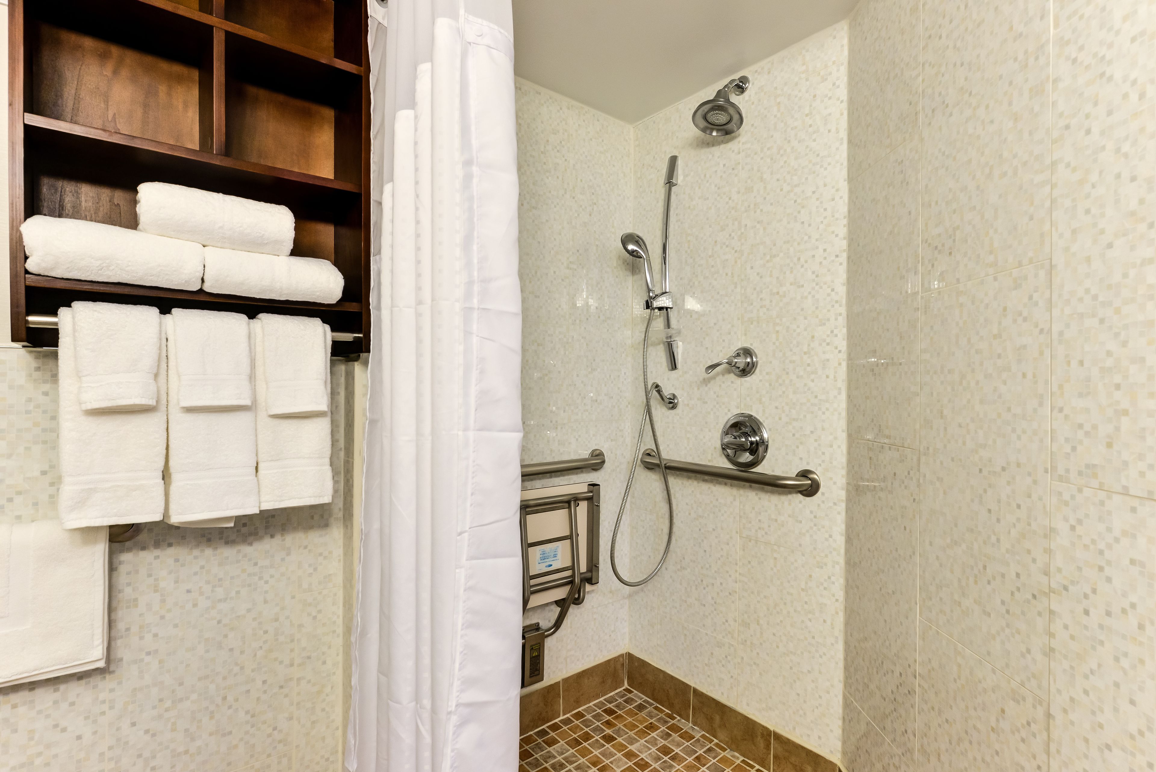 A shower with a handheld showerhead, a handheld showerhead, and a handheld showerhead.