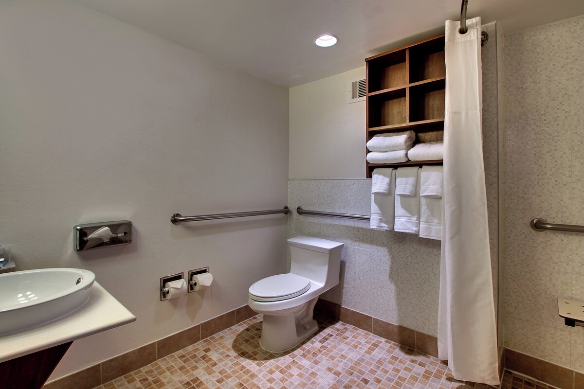 A bathroom with a toilet, sink, and shower curtain.