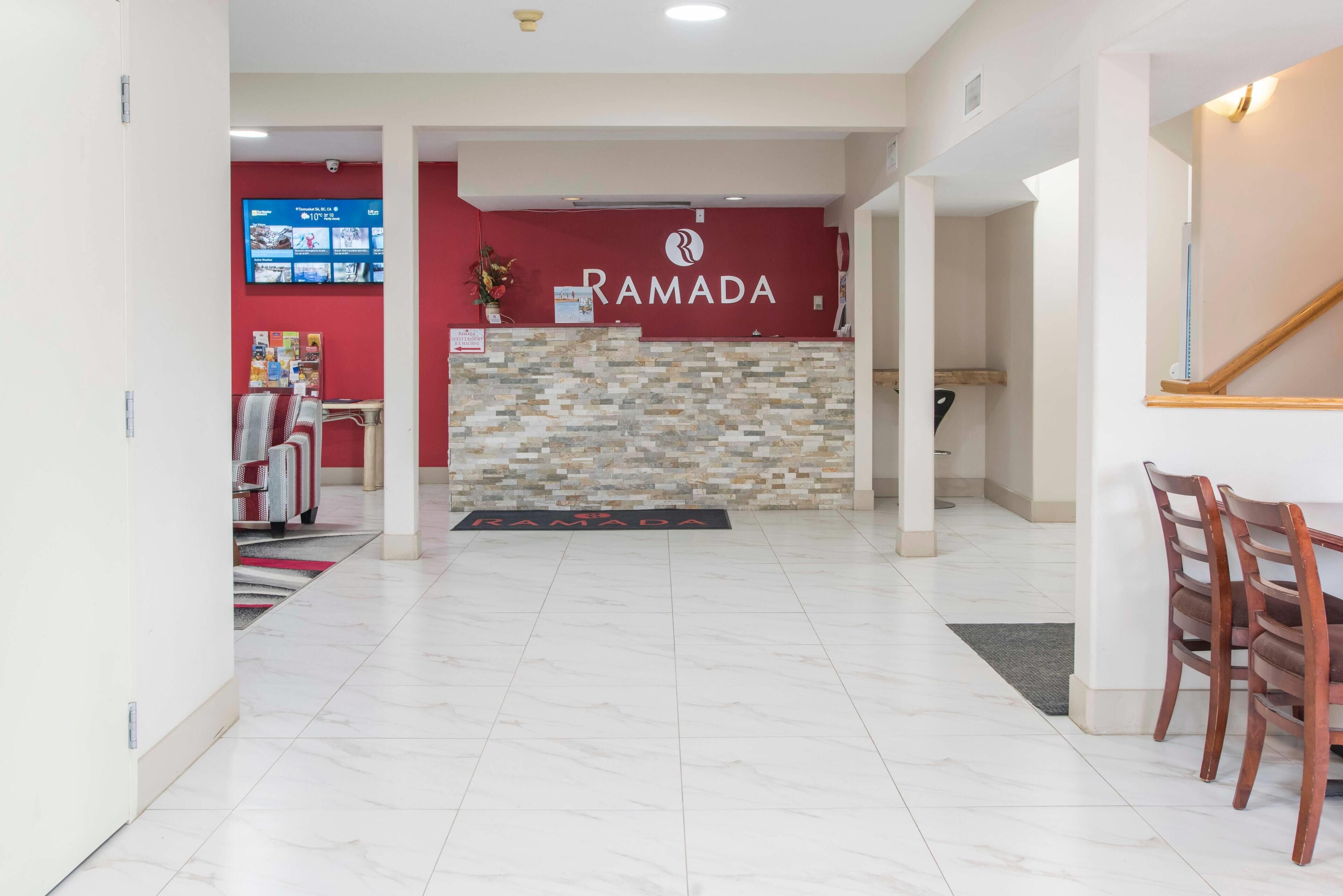 A reception area with a red wall and a stone-textured counter.