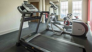 Uma academia com esteiras, elíptico e bicicleta ergométrica.