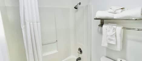 Un baño con bañera, inodoro y cortina de ducha.