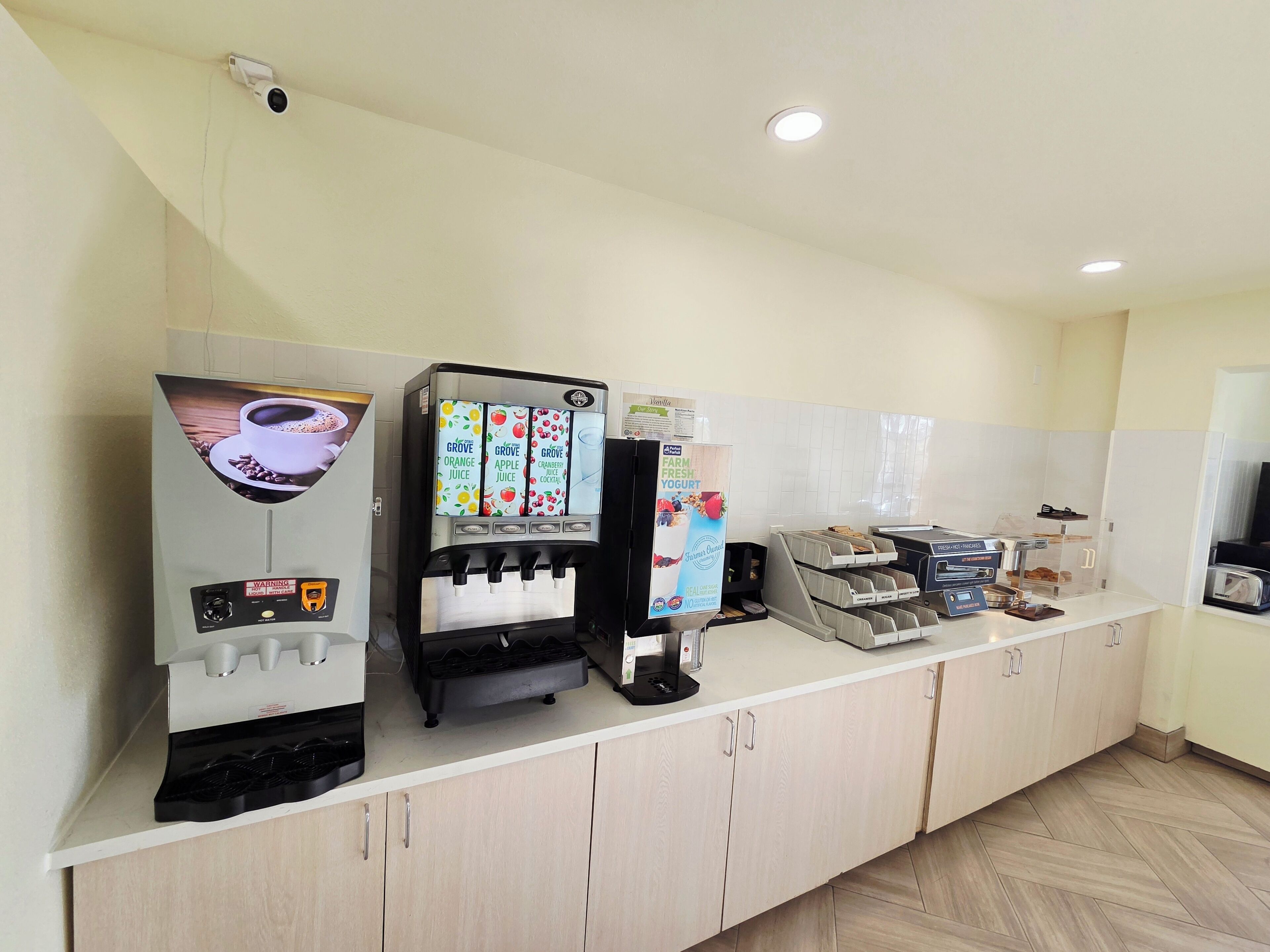 Una estación de autoservicio para bebidas con café, jugos y yogur.