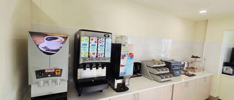 Una estación de autoservicio para bebidas con café, jugos y yogur.
