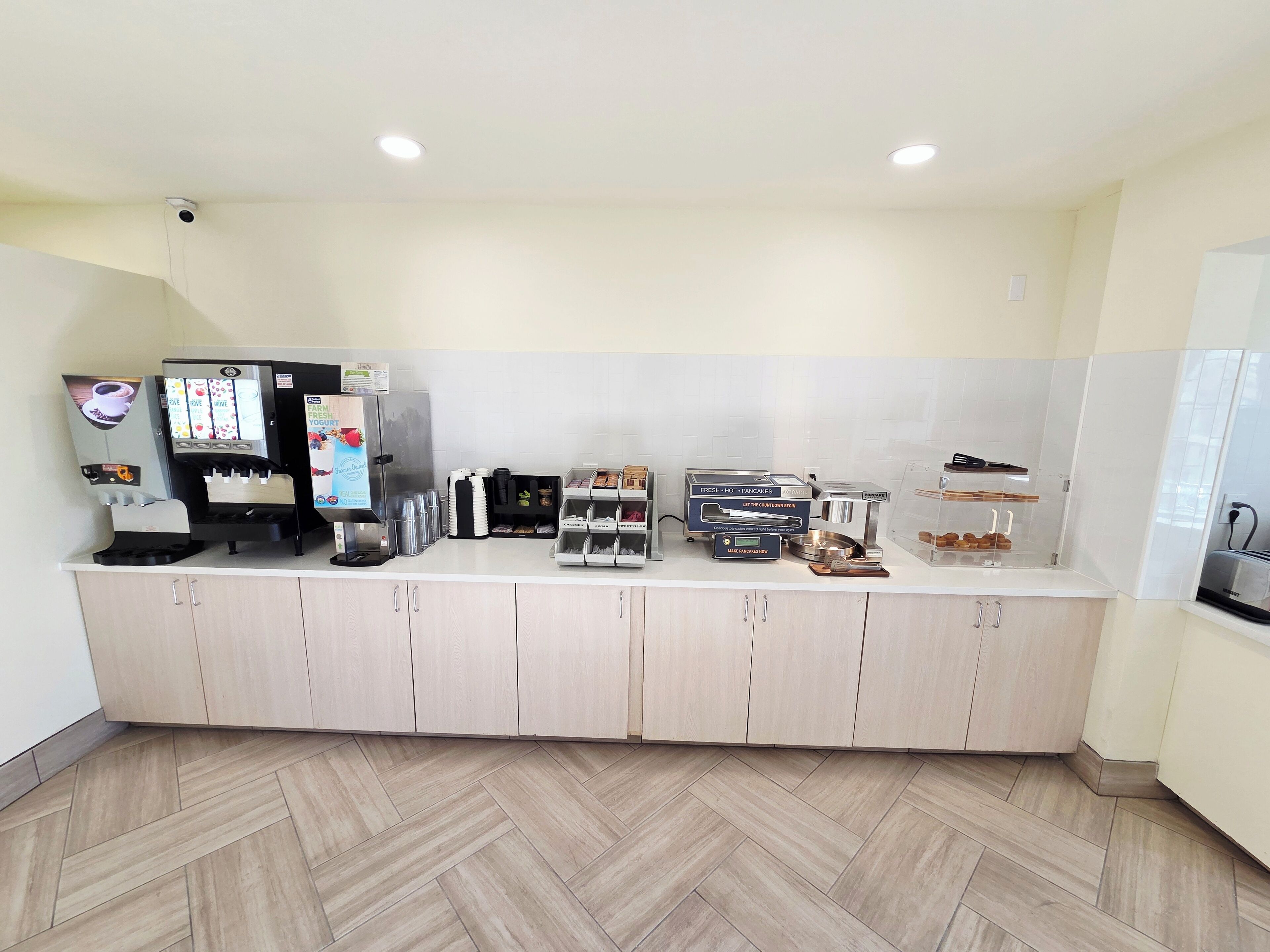 A kitchenette with a coffee machine, a toaster, and a refrigerator.