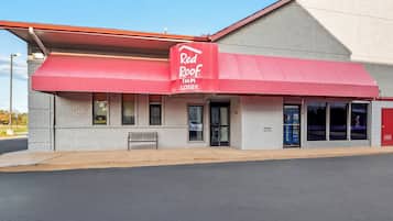 Een Red Roof Inn met een rode luifel en een gevel van baksteen.