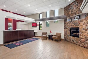 A reception area with a stone fireplace, a TV screen, and a reception desk.