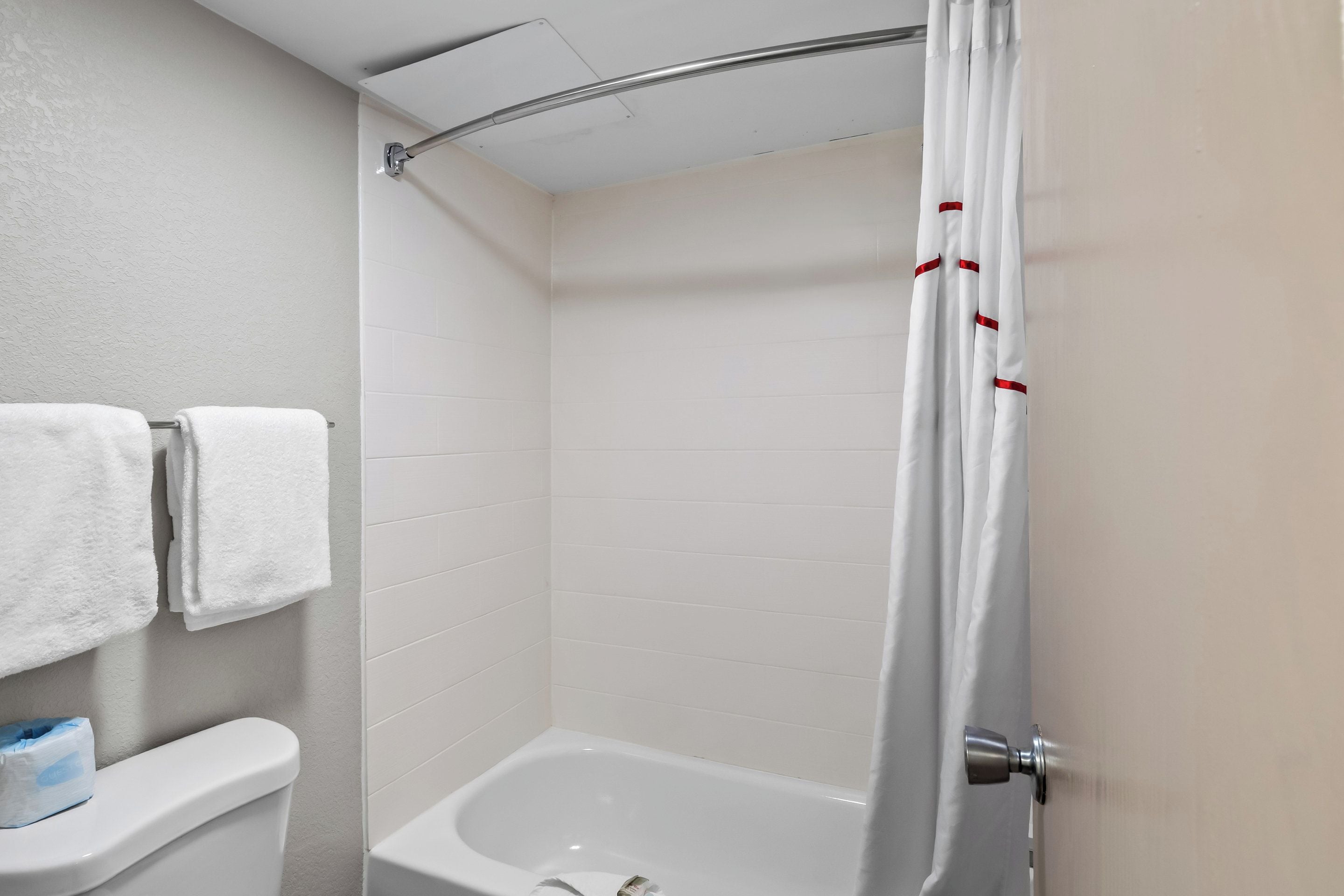 Un baño con bañera, inodoro y cortina de ducha.
