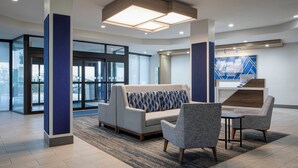 A modern lobby with a sofa, chairs, and a reception desk. - Holiday Inn Express Dallas Medical-Market Center by IHG (Dallas)