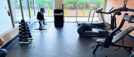 Una palestra con tapis roulant, macchinari ellittici e pesi liberi.