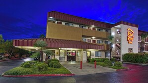 Een meerhoog hotel met een 'Red Roof Inn' bord, een 'Office' ingang en een parkeerplaats.