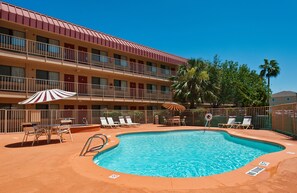 Una piscina al aire libre, sombrillas, tumbonas