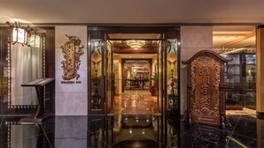 A polished lobby with a reception desk, a Dragon Inn sign, and a traditional wooden door. - Regal Airport Hotel (Chek Lap Kok)