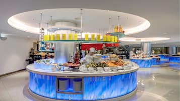 A modern buffet area with multiple serving stations, a central pillar, and overhead lighting.