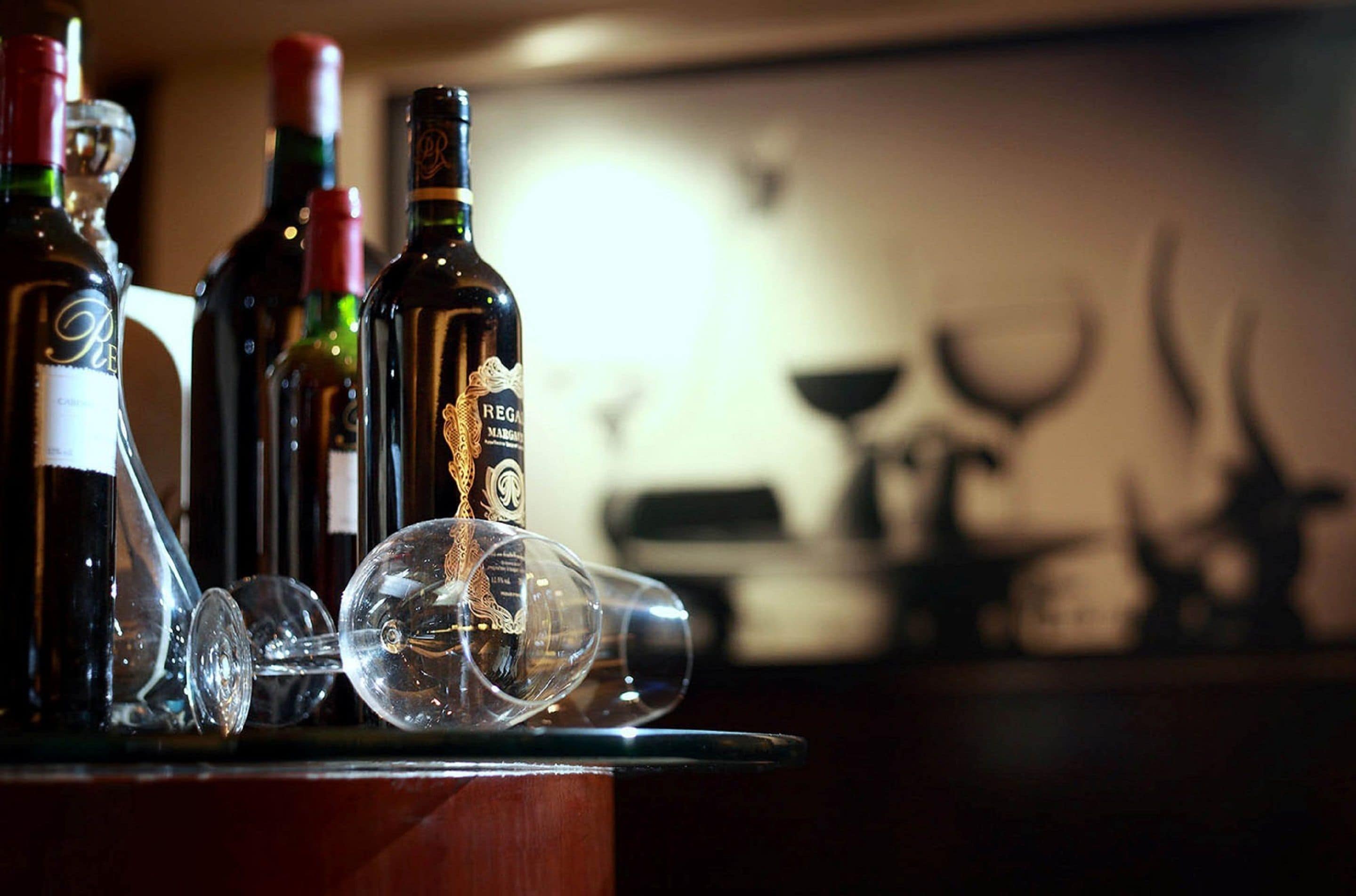 A bar area with bottles of wine and glasses.