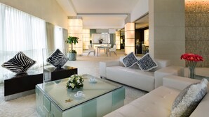 A modern hotel lobby with a seating area, a glass coffee table with flowers, and a large mirror. - Regal Airport Hotel (Chek Lap Kok)
