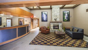 A lobby with a reception desk, a fireplace, a sofa, and a patterned rug. - Mountain Retreat Hotel (Squamish)