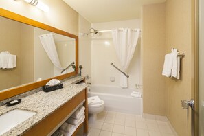 A hotel bathroom with a sink, mirror, towel rack, shower, and toilet. - Mountain Retreat Hotel (Squamish)