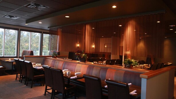 A conference room with a long table and chairs, large windows, and curtains. - Mountain Retreat Hotel (Squamish)