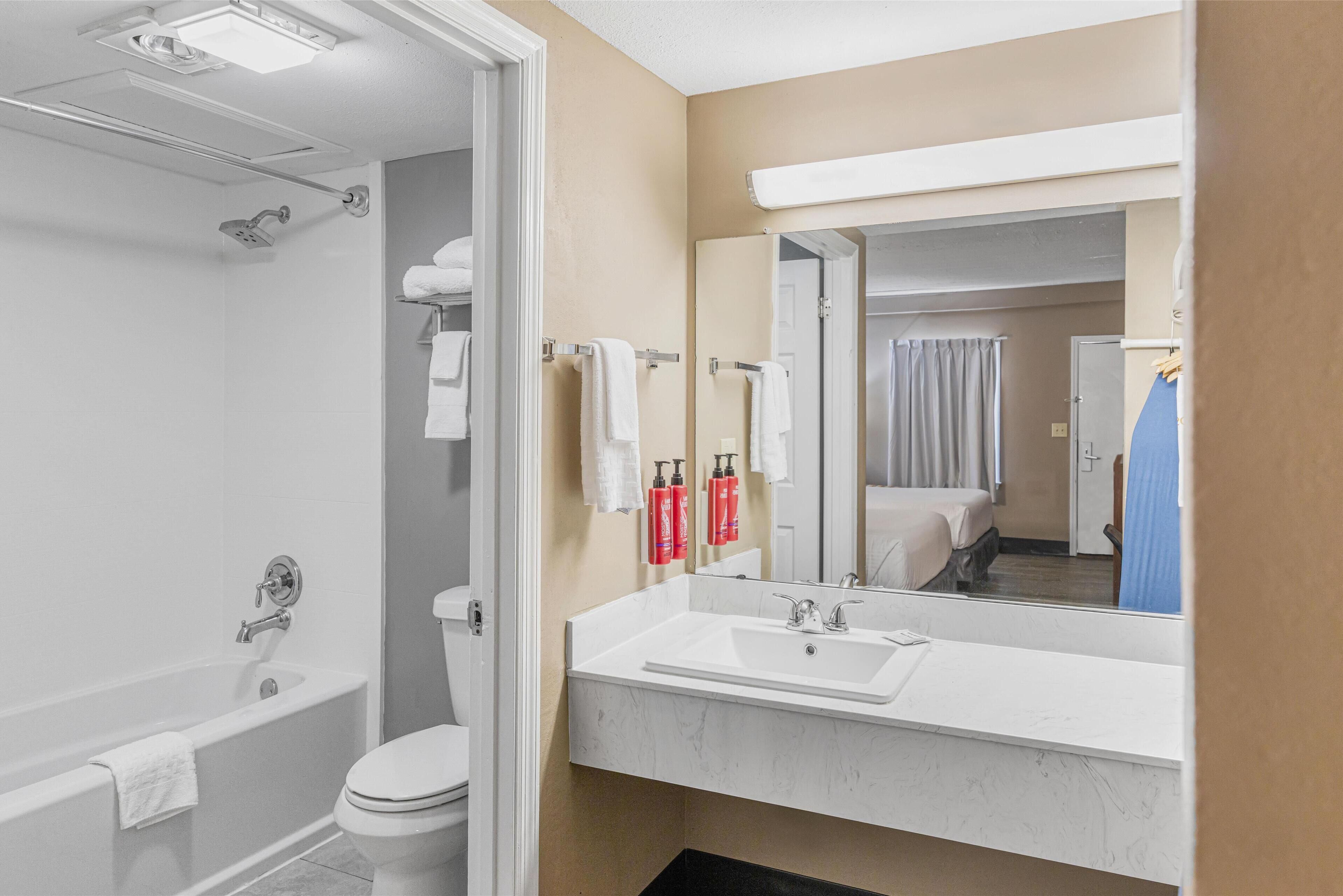 A modern bathroom with a bathtub, toilet, and sink.