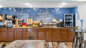 Un comptoir-repas équipé de machines à café, d’un four à micro-ondes et d’un réfrigérateur.