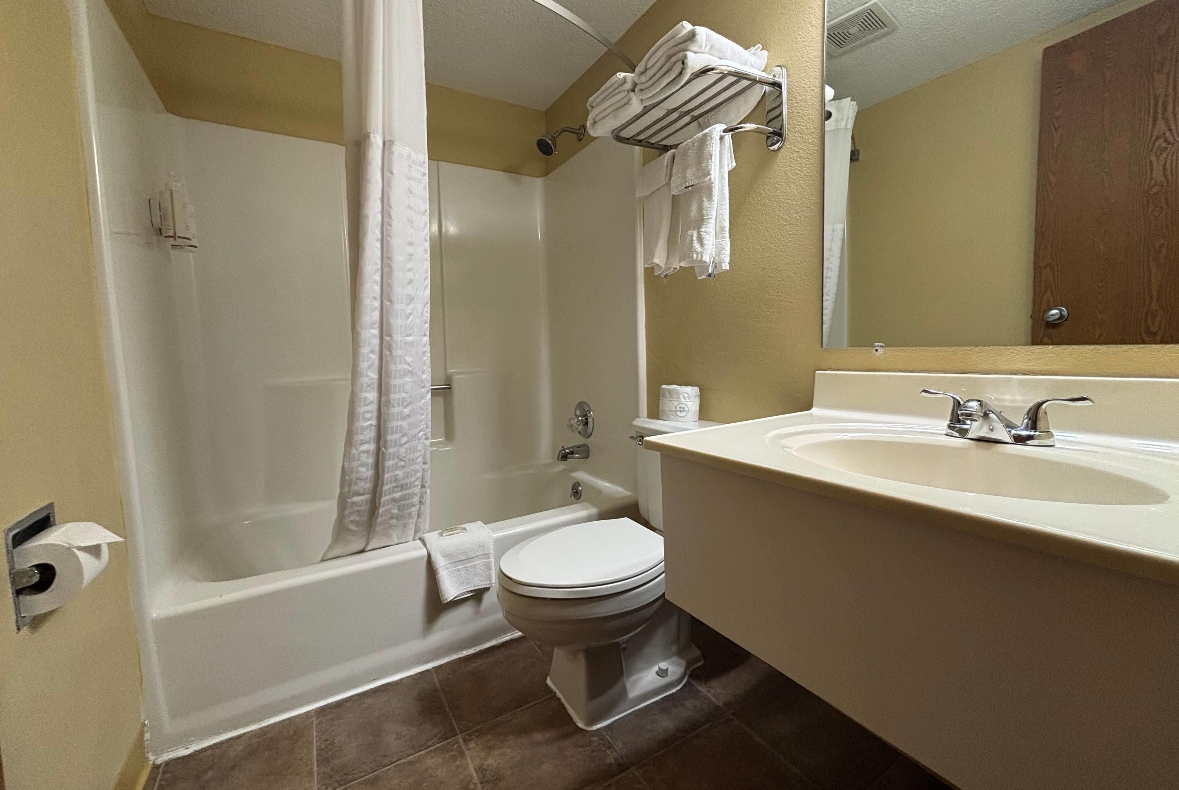 Un baño con bañera, inodoro y lavamanos.
