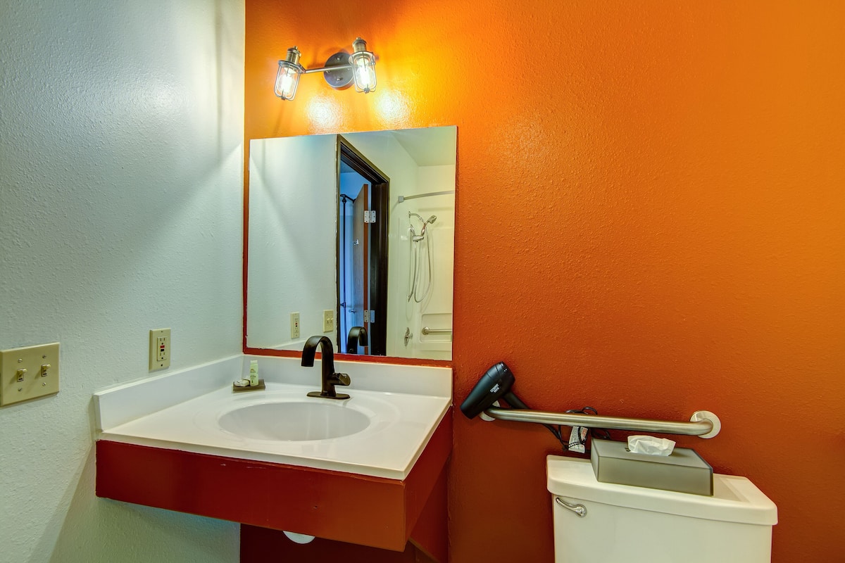 Une salle de bain avec un lavabo blanc, un miroir et un porte-serviettes.