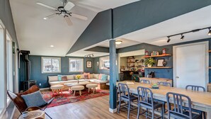 A spacious living area with a wooden dining table, multiple chairs, a sofa, and a ceiling fan. - Loyal Duke Lodge (Salida)