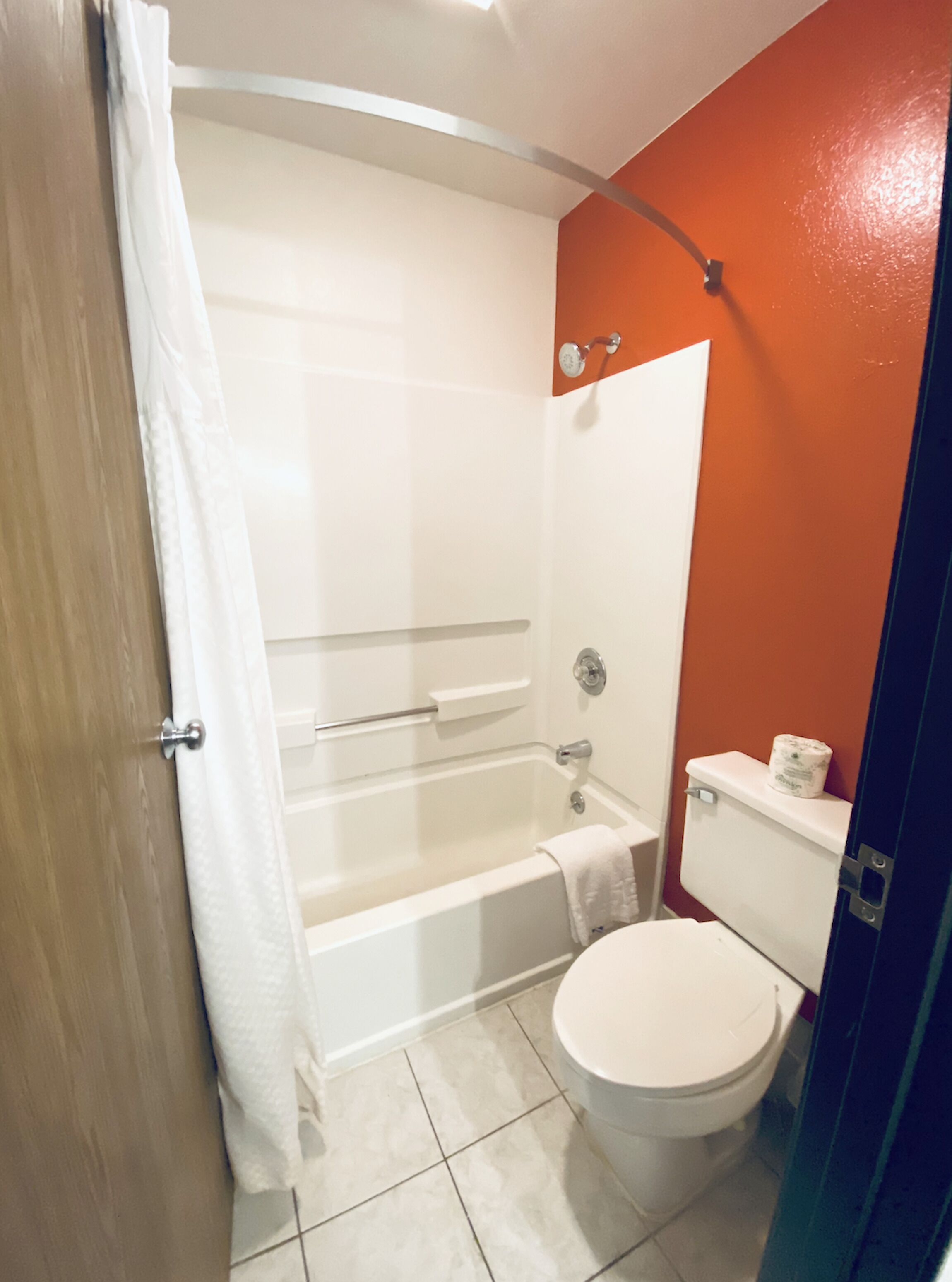 Un baño con bañera, inodoro y cortina de ducha.