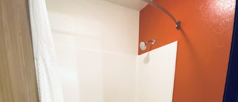 Un baño con bañera, inodoro y cortina de ducha.