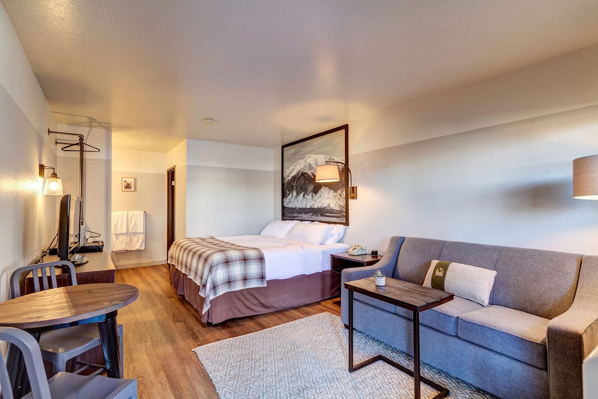 Une chambre d’hôtel avec un lit, un canapé, un bureau et une chaise.