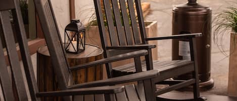 A wooden bench with a backrest and armrests, positioned on a concrete surface.