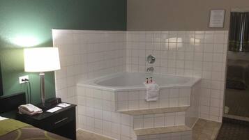 A bathroom with a bathtub, a towel rack, a sink, and a mirror.